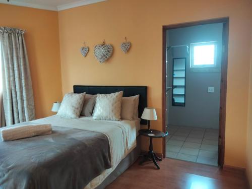 een slaapkamer met een bed en een deur met harten aan de muur bij Blue Tides in Port Elizabeth