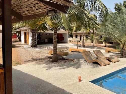 ein Resort mit einem Pool und Palmen in der Unterkunft LE 17 to DJIFFER in Palmarin