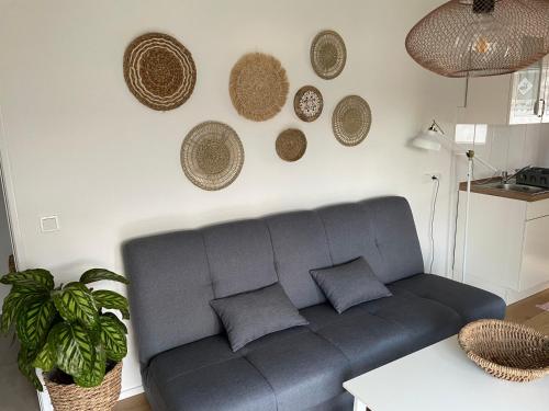 a living room with a gray couch and baskets on the wall at Ferienwohnung Jakob in Lindlar