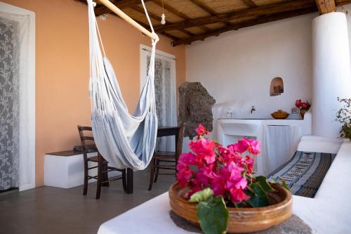 Habitación con hamaca y mesa con flores en Casa Serena en Filicudi