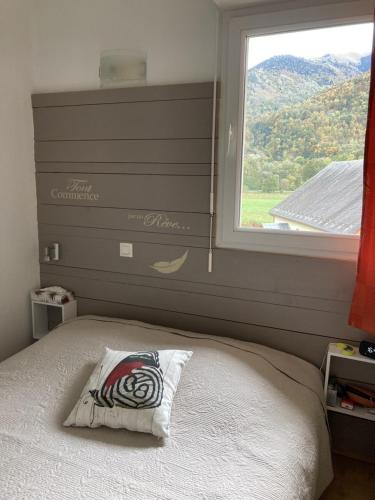 1 cama con almohada frente a una ventana en Appartement très agréable dans belle résidence, classé 3 étoiles par le comité départementale du tourisme en Haute Garonne, en Luchon