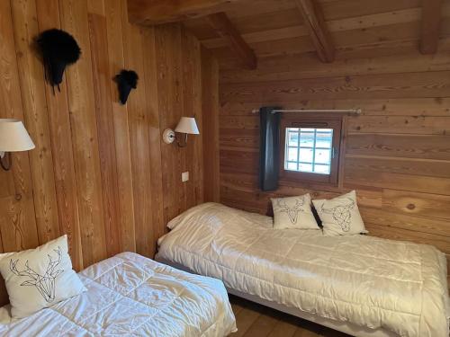 um quarto com 2 camas num chalé de madeira em Chalet l'écureuil La Plagne 8 pers La roche em Praconduit