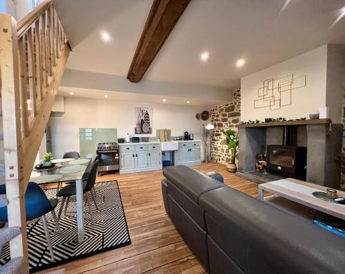 a living room with a couch and a fireplace at Gites Le Bisson in Heussé