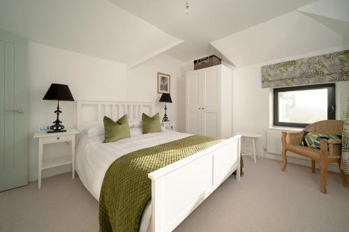 una camera da letto bianca con un letto grande e una finestra di Seymour Heights a Woolacombe