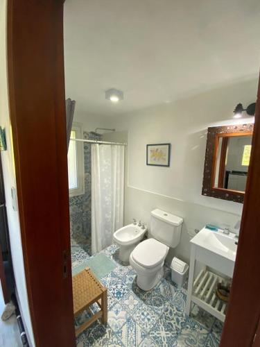Łazienka z białą toaletą i umywalką w obiekcie Los Mirlos w mieście La Cumbre