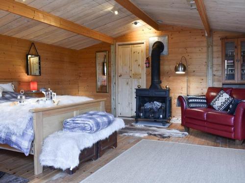 ein Bad mit einem Bett und einem Kamin in einer Hütte in der Unterkunft Easthorpe Retreat in Colchester