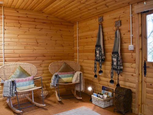 a room with two chairs and a wood wall at Easthorpe Retreat in Colchester