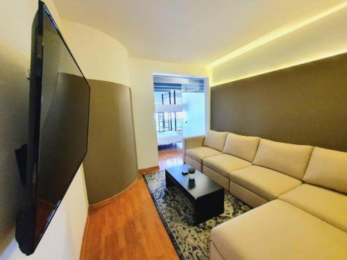 sala de estar con sofá blanco y TV en Linda Habitación Privada Polanco 2 camas Mat y baño en Ciudad de México