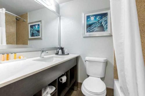 Baño blanco con aseo y lavamanos en Cielo Hotel Bishop-Mammoth, Ascend Hotel Collection en Bishop