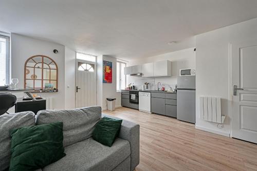 un salon avec un canapé et une cuisine dans l'établissement L'ESCALE -Climatisation- Proche CENTRALE TRICASTIN - WIFI - NETFLIX - Parking GRATUIT, à Lapalud