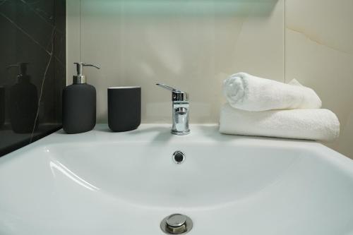 lavamanos con toallas y grifo en Accommodation in the center of Veria en Veria