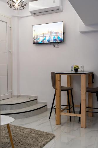 a living room with a table and a television on the wall at Veria Spot in Veria