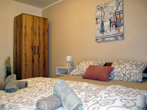 a bedroom with a bed and a wooden cabinet at Cezar in Arandjelovac
