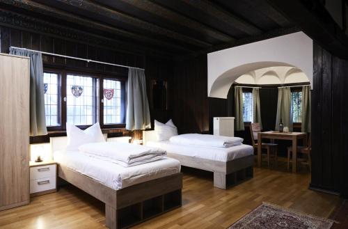 a bedroom with two beds and a table with a desk at Gentilburg und Gärtnerhaus Aschaffenburg in Aschaffenburg