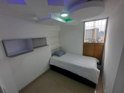 a small bedroom with a bed and a window at Apartamento ubicado en Bellas Artes in Caracas