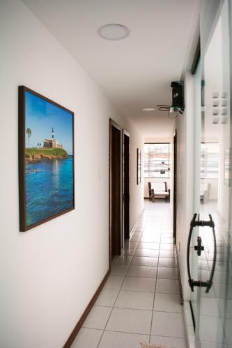 a hallway with a picture of the ocean on the wall at POUSADA PEDRA DE JACÓ in Lauro de Freitas