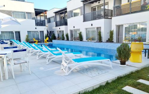 a row of chairs and tables next to a swimming pool at Bunga Bunga Resort Mamaia Nord in Mamaia Nord