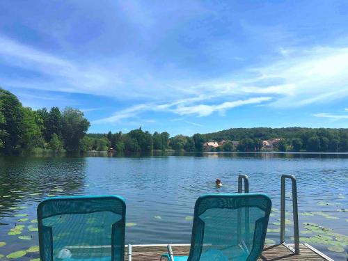 two chairs sitting on a dock on a lake at Ferienwohnung mit Sauna am Buckowsee in Buckow