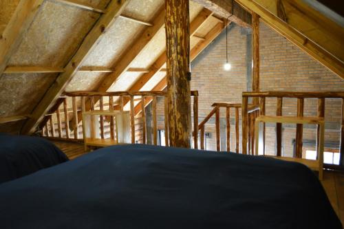 een loft met houten balken en een bed in een kamer bij Hermosa Cabaña de Montaña - Parque La Pirámide 