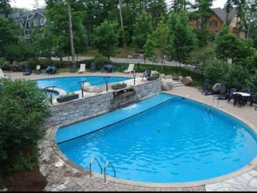 una grande piscina con un muro di mattoni intorno di Tremblant Luxury Mountain Getaway a Mont-Tremblant