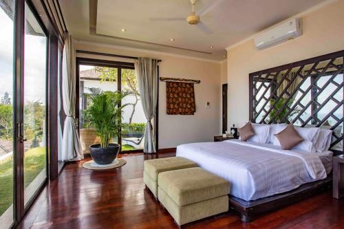 a bedroom with a large bed and a large window at Nusa Dua Ocean View 4 Bedroom Bibi Bali in Nusa Dua