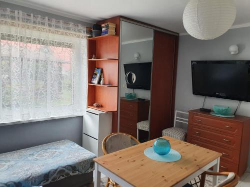 Habitación pequeña con mesa y TV. en Sztormowa 13, en Chałupy