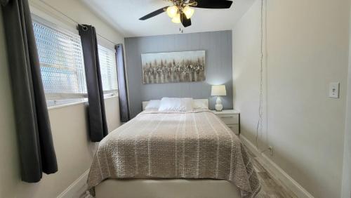 a bedroom with a bed and a ceiling fan at BEACHWAY INN in Lantana
