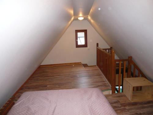 a attic room with a bed and a staircase at La cour des meuniers - le Froment et l'Epeautre in Kaysersberg