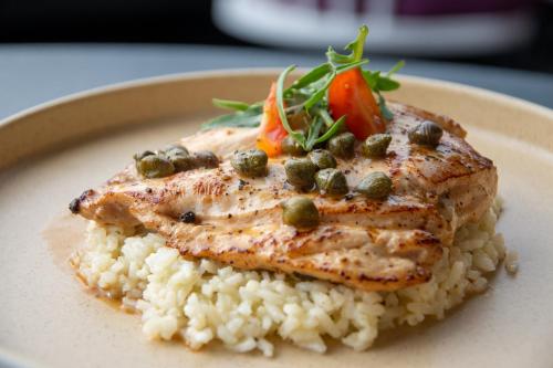 a plate of chicken and rice with a side of vegetables at The Xperience by g in Mazatlán