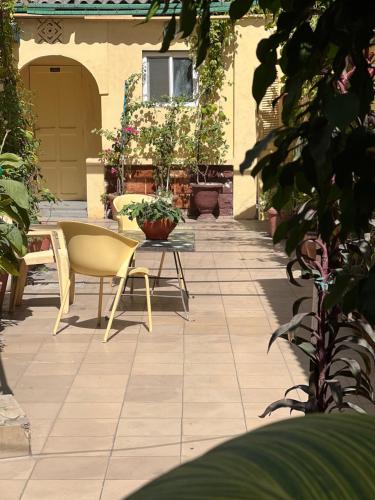 a patio with a table and chairs and plants at Hôtel Provençal in Dakar