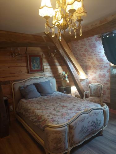 a bedroom with a bed and a chandelier at Studio Marcel Proust in Crasville-la-Mallet