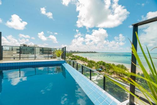 a swimming pool on the roof of a building with a view of the ocean at Vistamar Hotel in Maceió