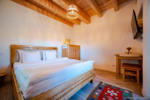 a bedroom with a large bed and a table at Dimineți în Cerdac in Piatra Neamţ