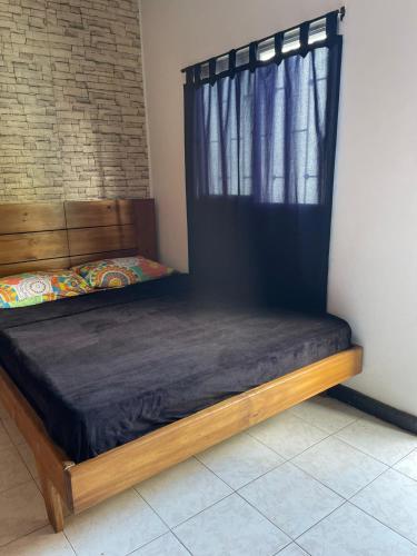 a bed sitting in a room with a window at Rock Hostel Medellin in Medellín