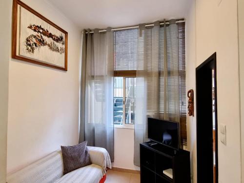 - un salon avec un canapé et une fenêtre dans l'établissement Anjos Apartment - Ilha do Príncipe, à Lisbonne