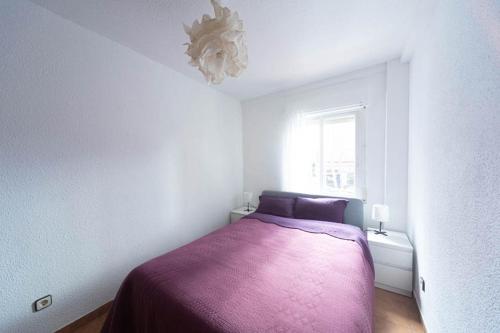 a bedroom with a purple bed and a window at Cañada in Alcorcón
