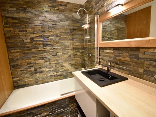 La salle de bains est pourvue d'un lavabo et d'un mur en briques. dans l'établissement Triplex rénové aux Dromonts, Avoriaz - 6/7 pers, 3 ch, balcon, proche centre village - FR-1-633-38, à Morzine