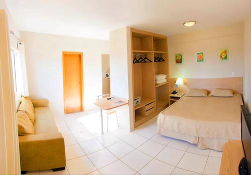 1 dormitorio con 1 cama y 1 sofá en una habitación en Ap 618 - Golden Dolphin Express, en Caldas Novas