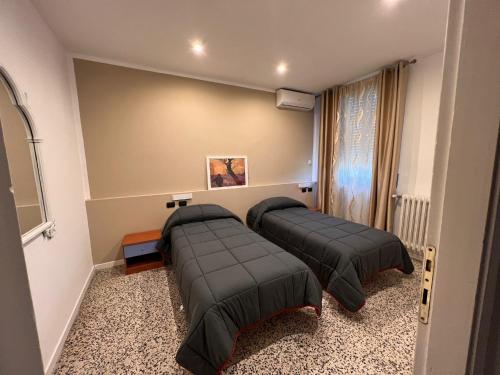 a room with two beds in a room at Hotel Saratoga in Vigevano