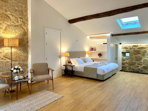 a bedroom with a bed and a table and a chair at Quinta da Porta - Solar de Vale de Prazeres in Vale de Prazeres