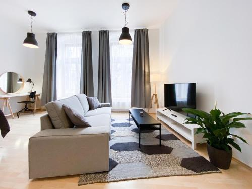 a living room with a couch and a tv at Residence Caesar by Homester in Brno