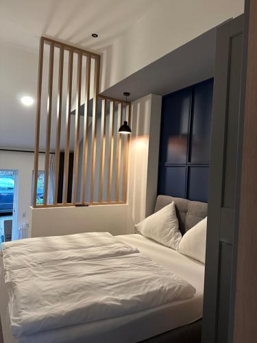 a bedroom with a white bed with a blue headboard at Hotel zur Post Dabringhausen in Wermelskirchen