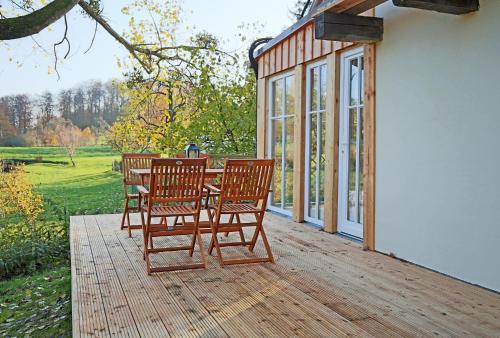 a patio with three chairs and a table on a deck at Naturerlebnis in Malchin