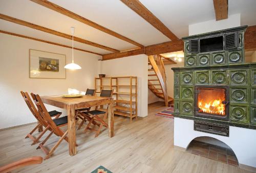 a dining room with a fireplace and a table with chairs at Naturerlebnis in Malchin