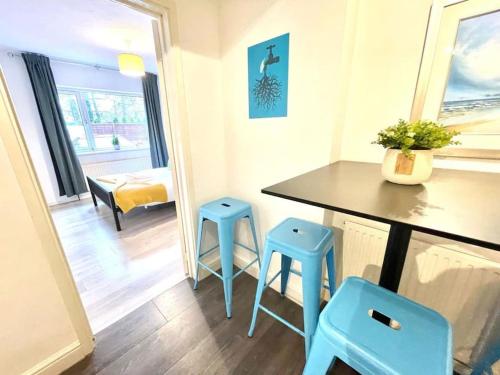 uma cozinha com dois bancos azuis num quarto em Serene and Cozy 1-Bedroom House with Parking em Cambridge