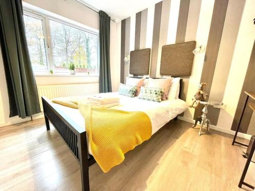 een slaapkamer met een groot bed en een gele deken bij Serene and Cozy 1-Bedroom House with Parking in Cambridge