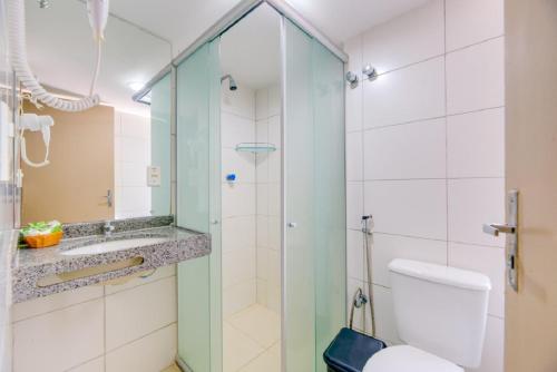 a bathroom with a glass shower and a toilet at Vistamar Hotel in Maceió