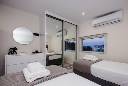 um quarto com 2 camas, um lavatório e um espelho em Home Sweet Home - Big Balcony with Great View em Kissamos