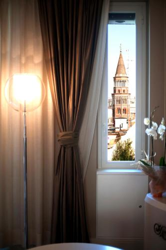 a room with a window with a curtain and a lamp at Suite Milano Duomo in Milan