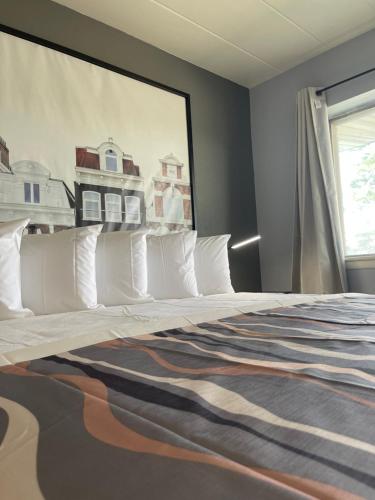 a bedroom with a large bed with white pillows at Valued Stay Aloha in Madison